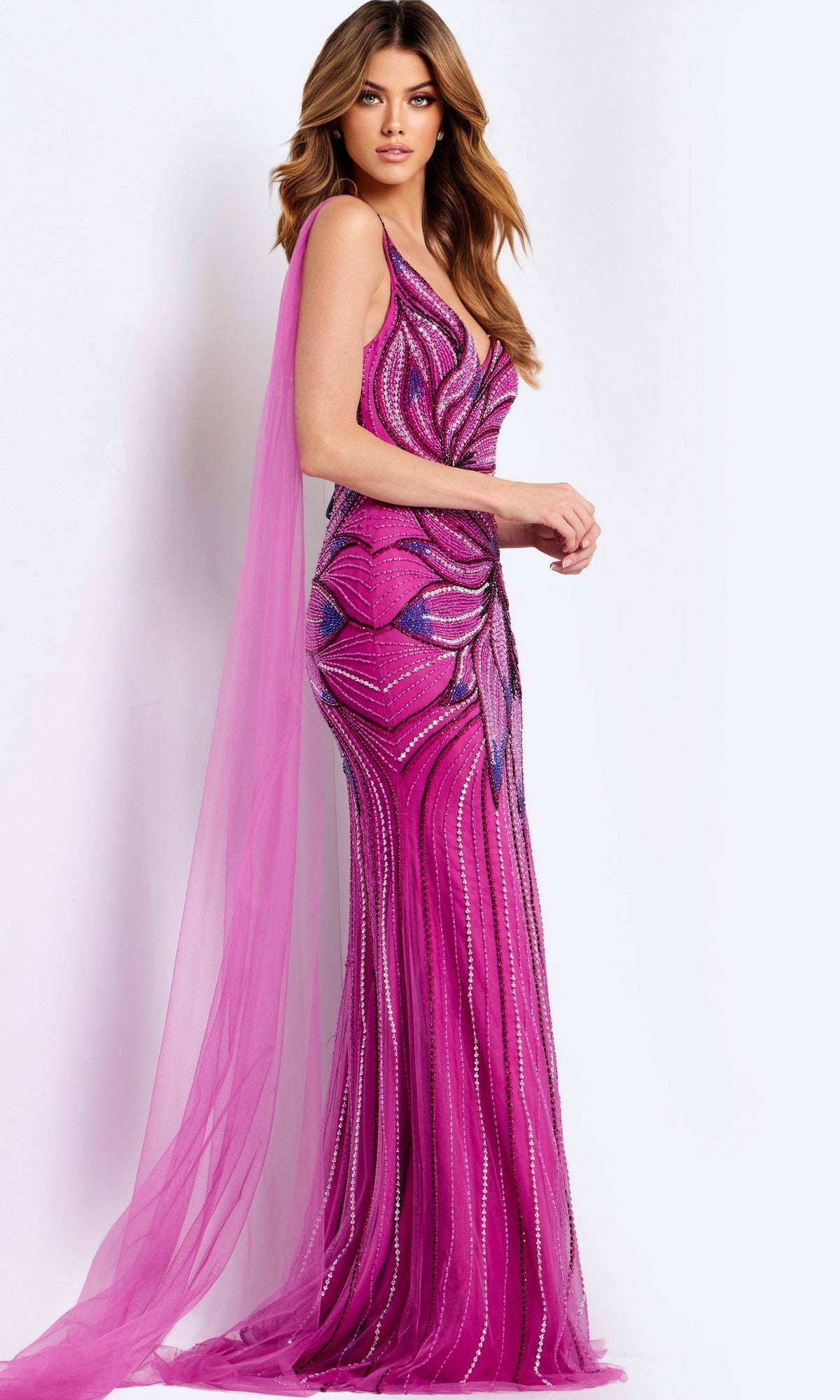 A woman stands against a plain light background wearing the Jovani 45876, a fitted floor-length magenta prom dress featuring geometric beading and a sheer cape detail.